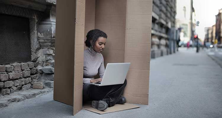 Mujer que trabaja en la computadora portátil mientras está sentada en la caja