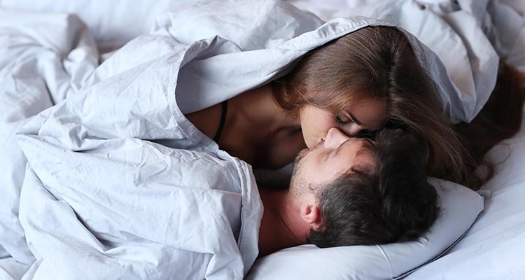 joven pareja apasionada besándose en la cama